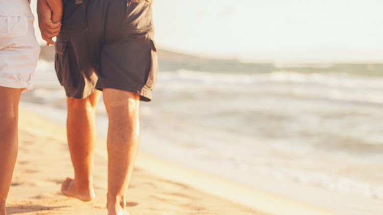 et par ikledd shorts går tur på en strand. foto.
