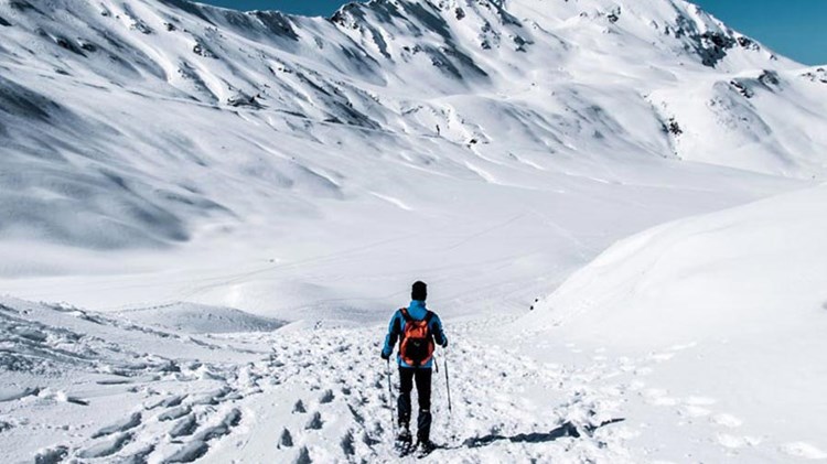 mann på skitur i snødekte fjell. foto. 