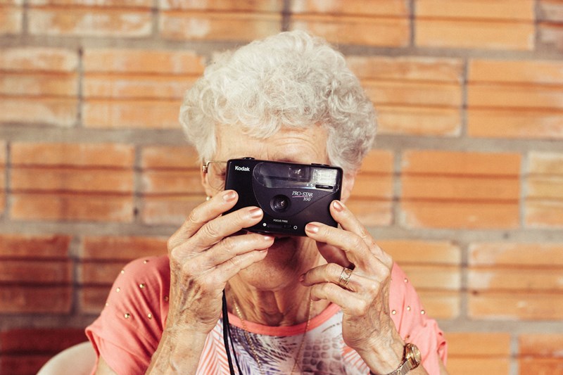 Eldre kvinne som holder et kamera